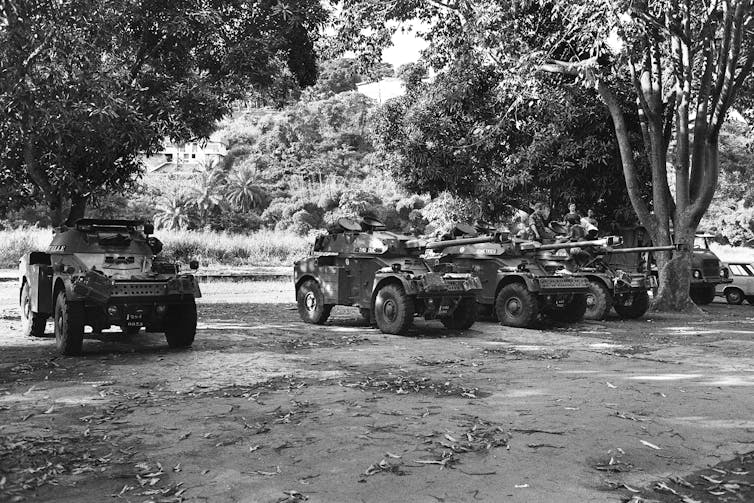 Tanques posicionados em uma estrada de terra.